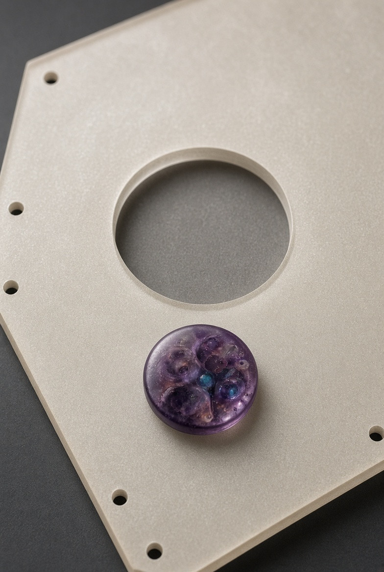 An editorial resin token separated from an empty official seal recess